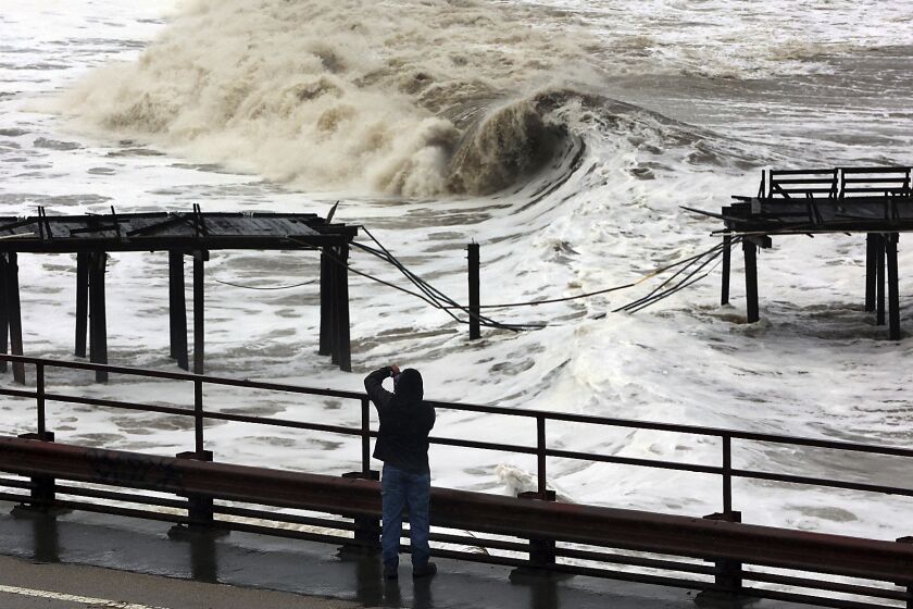 Powerful waves batter the Capitola Wharf after the storm destroyed a section of the structure  in Capitola, Calif. 