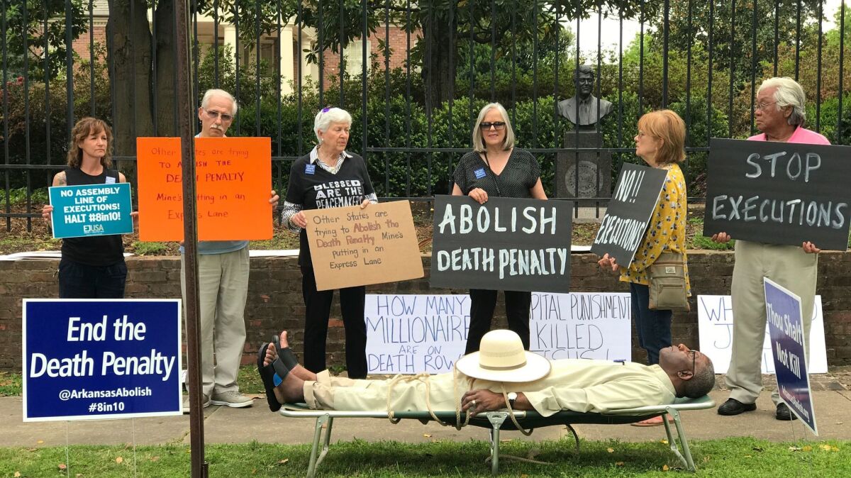 Opponents to the death penalty, including Pulaski County Circuit Judge Wendell Griffen, on a cot, rally outside the mansion of Arkansas Gov. Asa Hutchinson on Friday.