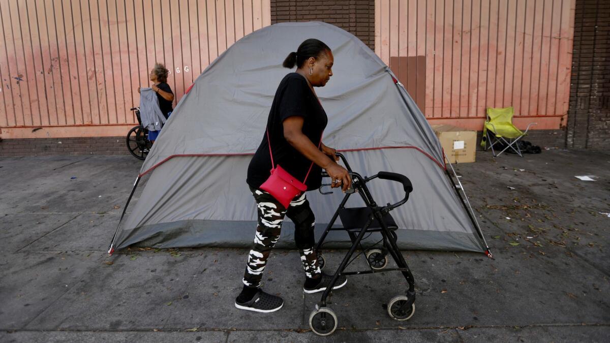 Royce Cutrer, 54, walks past a tent in the skid row area of Los Angeles.