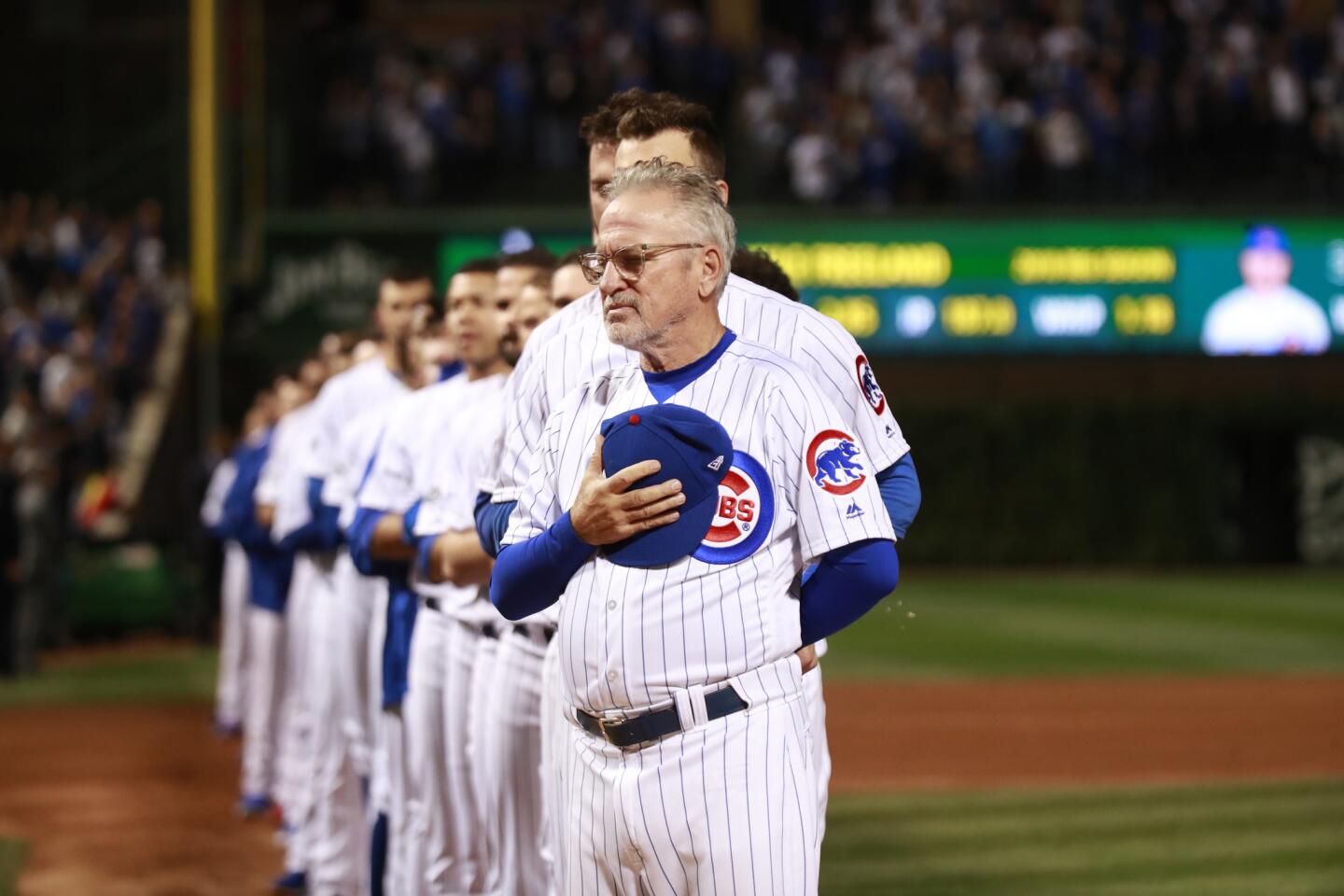 Cubs manager Joe Maddon and his team stand for the national anthem before the National League wild-card game Tuesday, Oct. 2, 2018, at Wrigley Field.