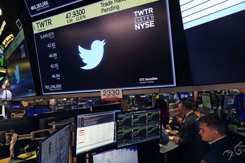 The symbol for Twitter appears above a trading post on the floor of the New York Stock Exchange, Tuesday, Oct. 4, 2022. Trading in shares of Twitter was halted after the stock spiked on reports that Elon Musk would proceed with his $44 billion deal to buy the company after months of legal battles.(AP Photo/Seth Wenig)