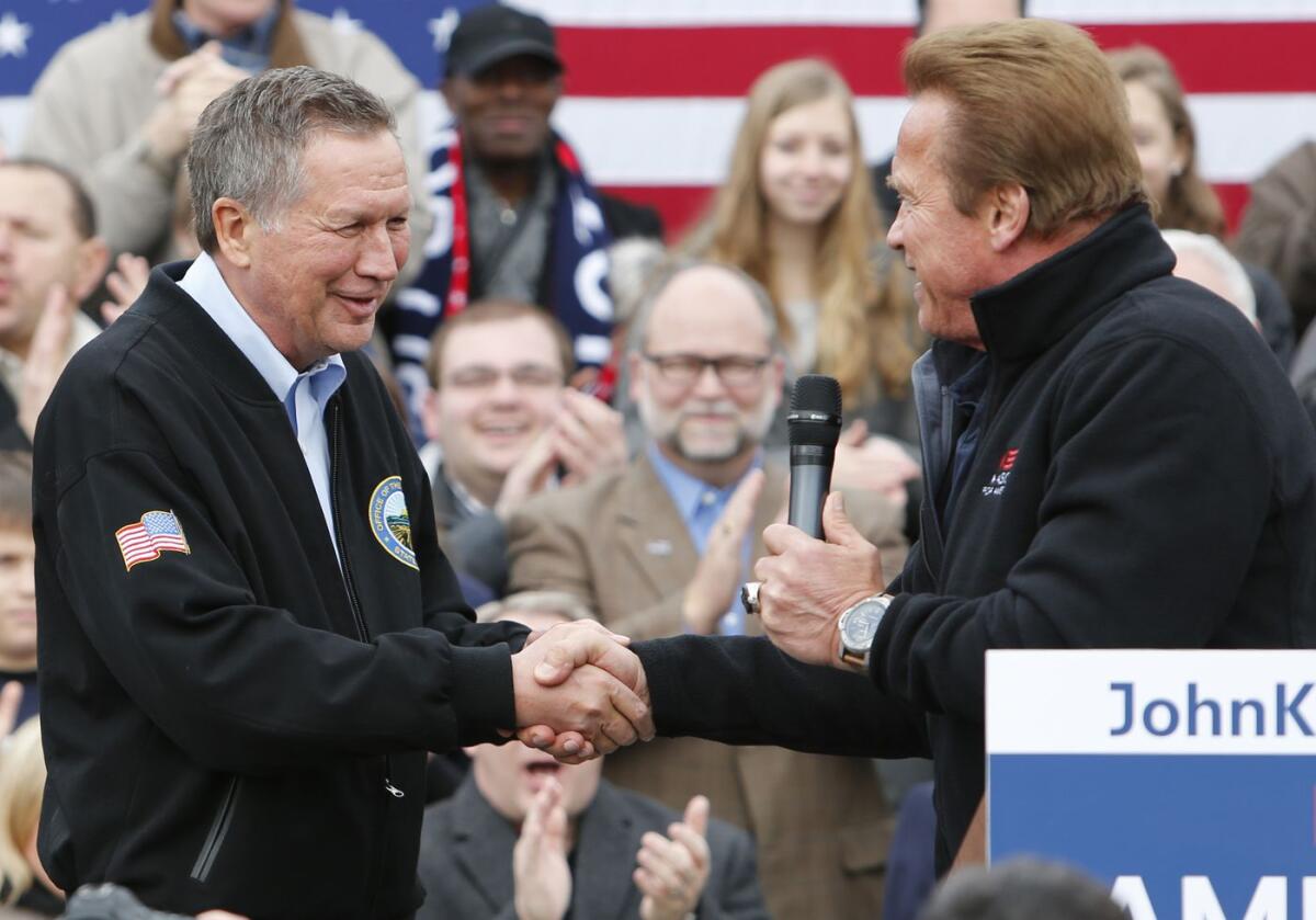 Ohio Gov. John Kasich, left, shakes hands with former California Gov. Arnold Schwarzenegger.