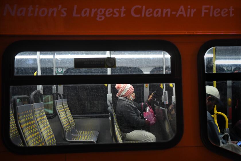 LOS ANGELES, CALIFORNIA MARCH 26, 2020-A passenger wears a mask on a Merto bus during a coronavirus outbreak in Downtown Los Angeles. (Wally Skalij/Los Angeles Times)