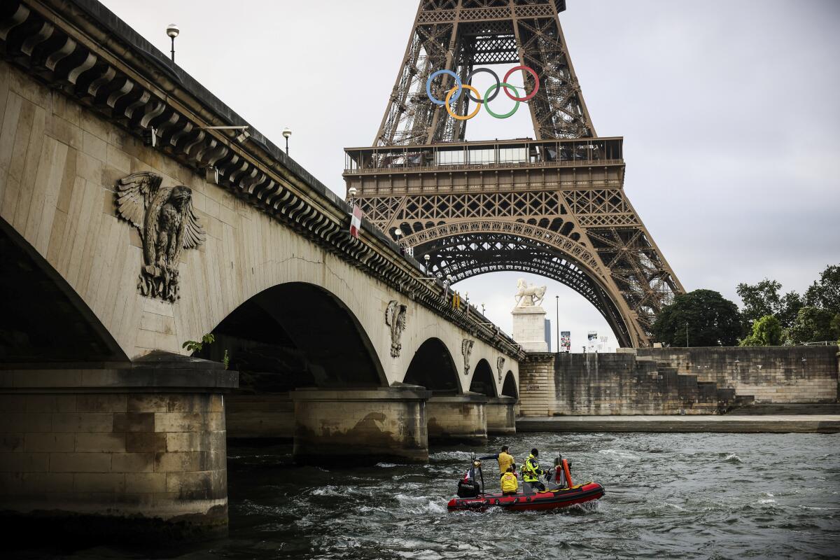 Un bote de rescate navega en el río Sena cerca de la Torre Eiffel durante un simulacro para la ceremonia 