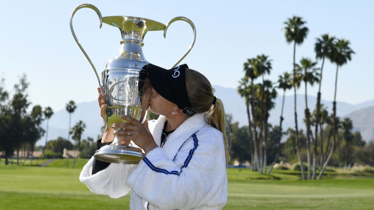 Pernilla Lindberg kisses the winner's trophy after defeating Inbe Park of South Korea on the eighth sudden-death playoff hole at the ANA Inspiration in Rancho Mirage.