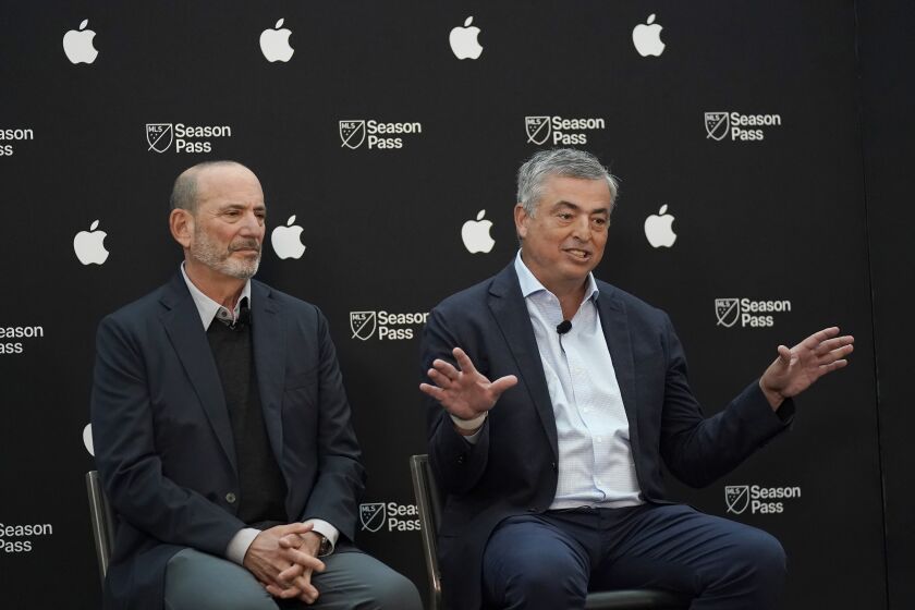 Apple senior vice president of services Eddy Cue, right, speaks next to Major League Soccer Commissioner Don Garber during a MLS Season Pass and Apple TV talent announcement at MLS soccer media day in San Jose, Calif., Tuesday, Jan. 10, 2023. (AP Photo/Jeff Chiu)