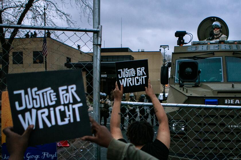 BROOKLYN CENTER, MN - APRIL 14: Protesters gather outside the Brooklyn Center Police Department calling for justice for Daunte Wright before curfew on Wednesday, April 14, 2021 in Brooklyn Center, MN. (Jason Armond / Los Angeles Times)