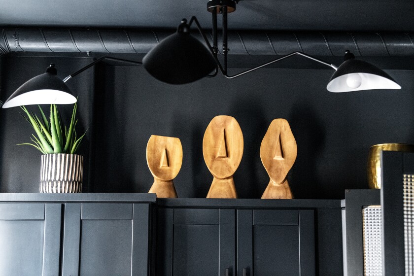 African wood sculptures rest on top of kitchen cabinets. 