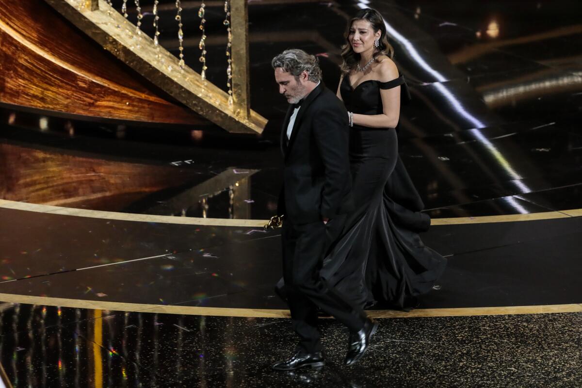 Joaquin Phoenix exits the stage after accepting his Oscar.