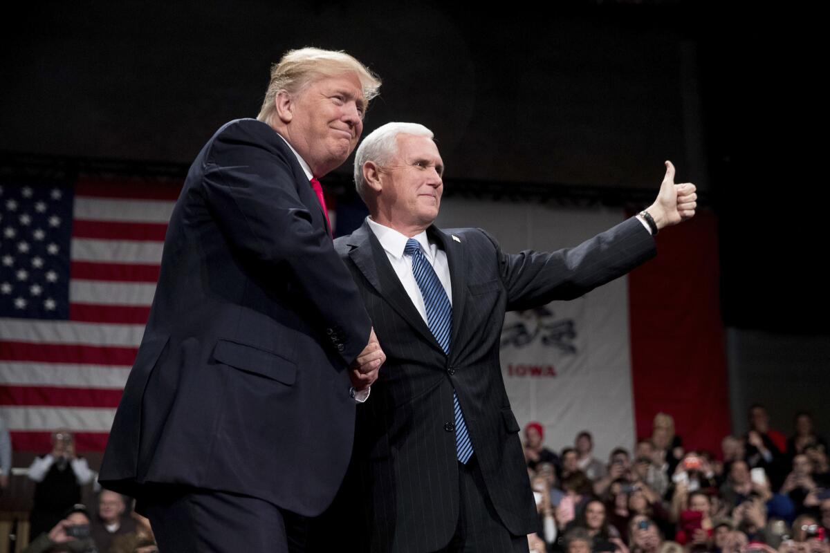 President-elect Donald Trump, left, takes the stage after Vice President-elect Mike Pence introduces him at a rally Thursday at Hy-Vee Hall in Des Moines, Iowa.