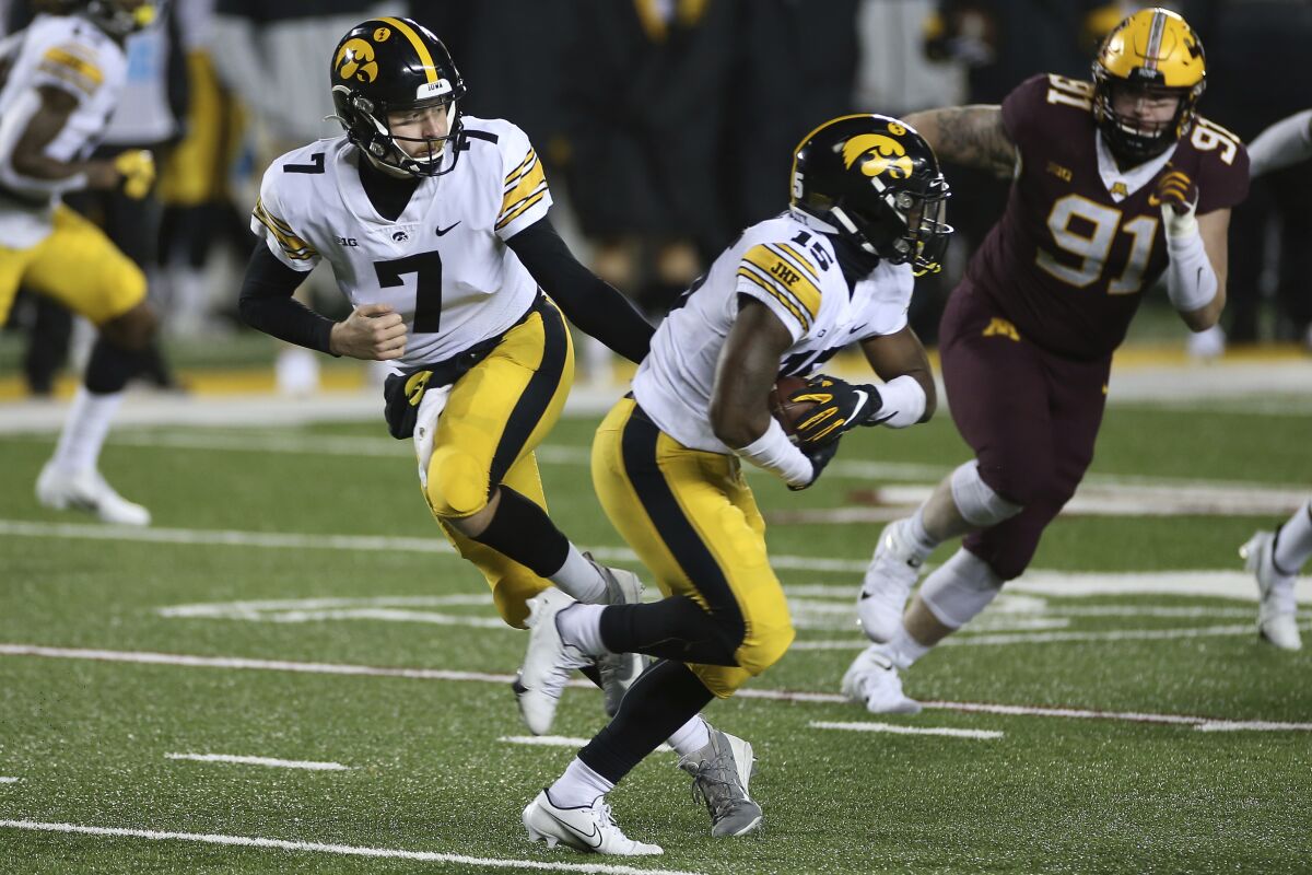 Iowa quarterback Spencer Petras hands the ball off to running back Tyler Goodson on Nov. 13, 2020.