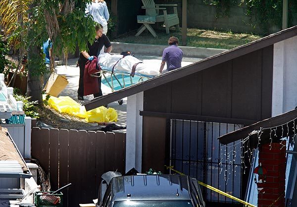 Medical examiners move the body of an adult found dead with three other family members in a home in the Skyline neighborhood of San Diego. See full story