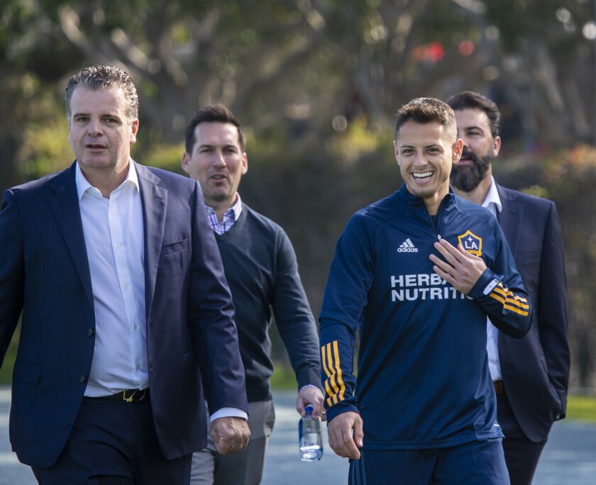 Galaxy GM Dennis te Kloese, left, walks with star Javier "Chicharito" Hernandez onto the practice field 