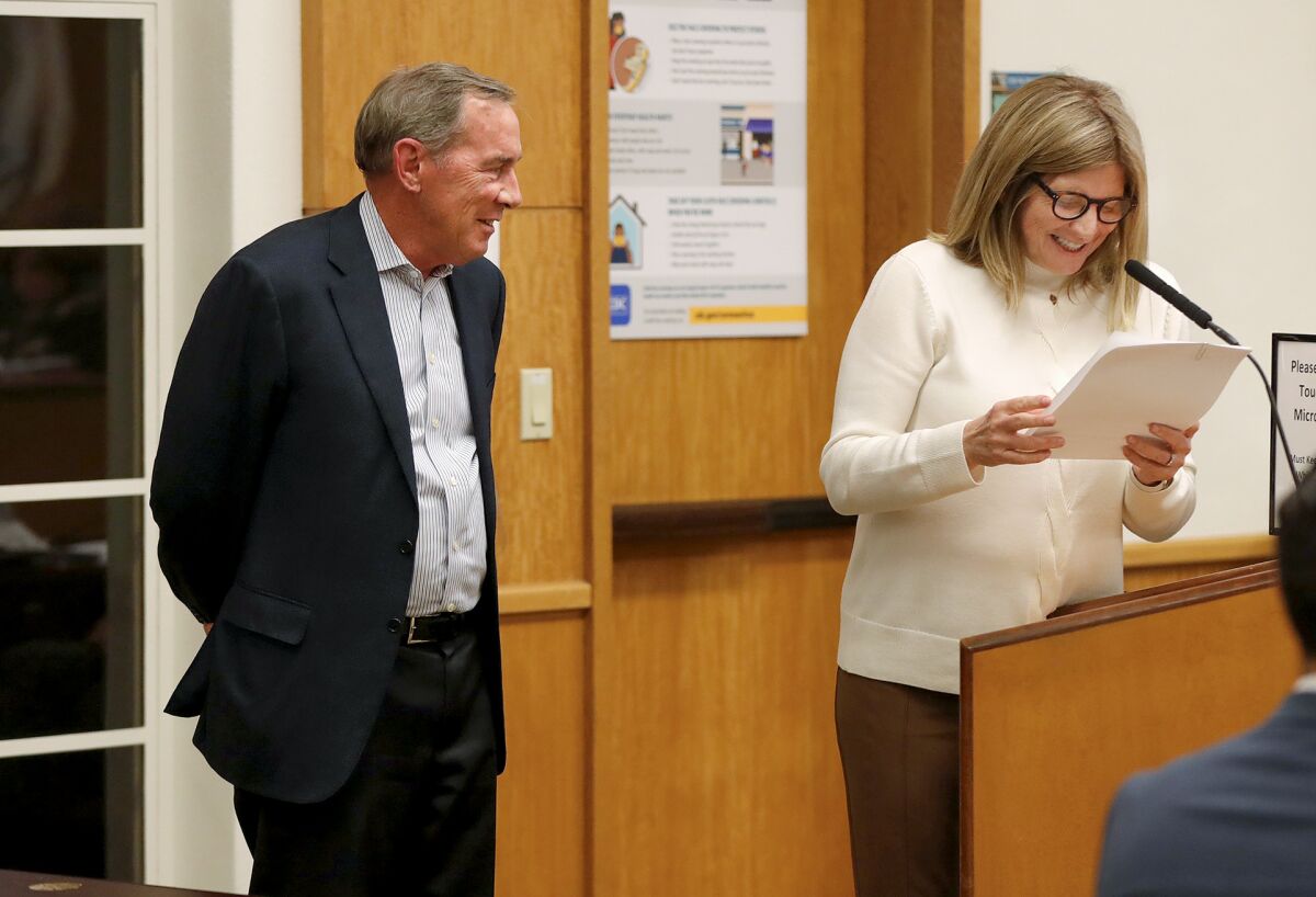 Newly appointed mayor Sue Kempf, right, reads a list of accomplishments by three-year, outgoing mayor Bob Whalen.
