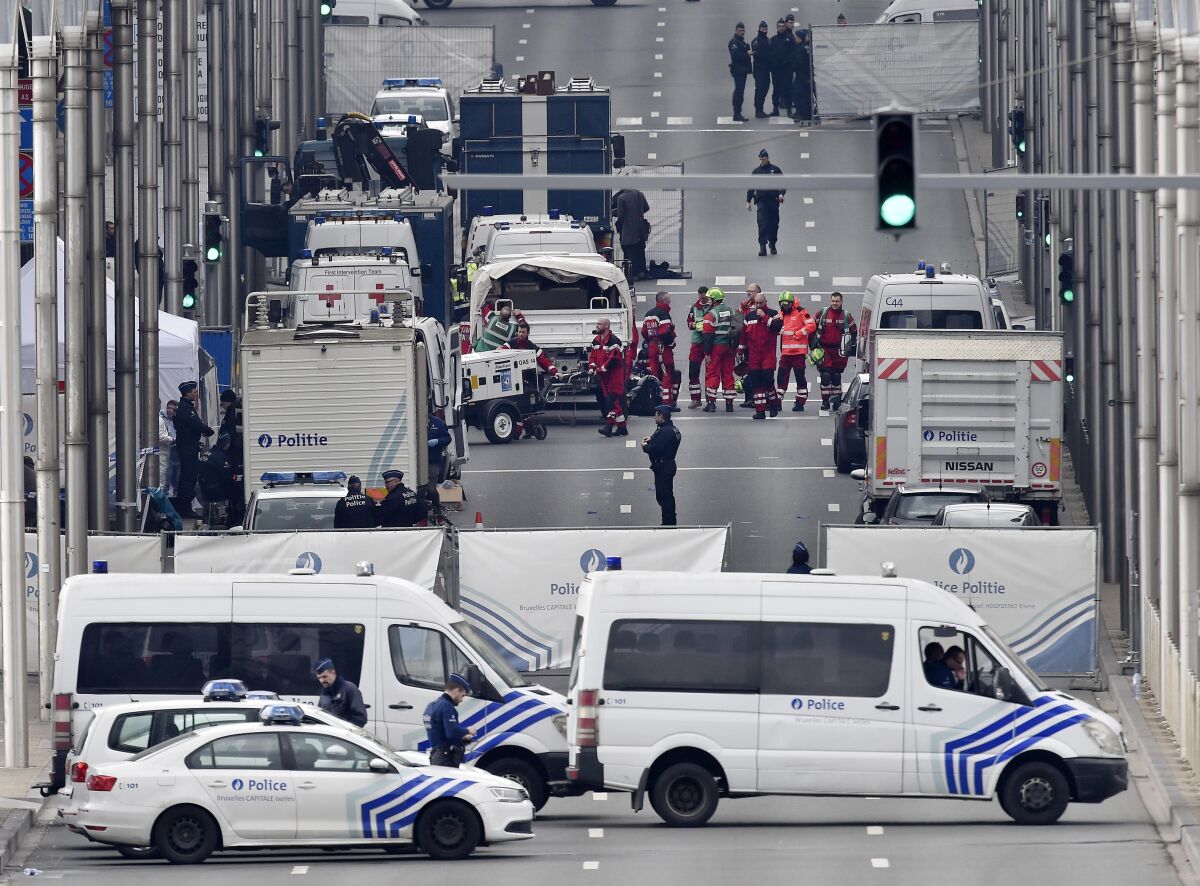 FILE - In this Tuesday, March 22, 2016 file photo, police and rescue teams are pictured outside the metro station Maelbeek in Brussels. The trial of 10 men accused over the 2016 suicide bombings at Brussels airport and an underground metro station starts in earnest this week. Survivors, and relatives of the 32 people killed in the deadliest peacetime attacks on Belgian soil, are hoping the trial will bring them closure. (AP Photo/Martin Meissner, File)