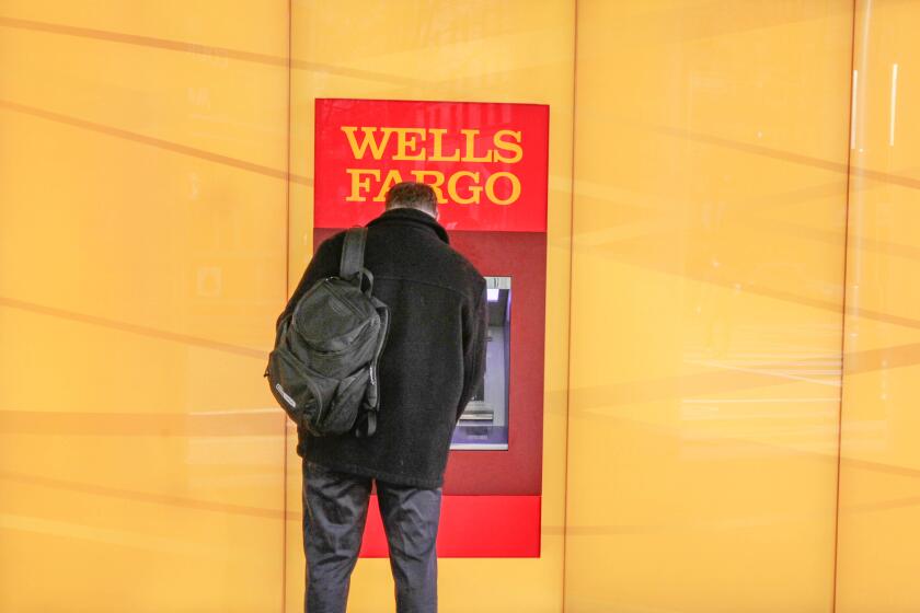 A customer uses an ATM outside a Wells Fargo branch in Charlotte, N.C. in 2012.