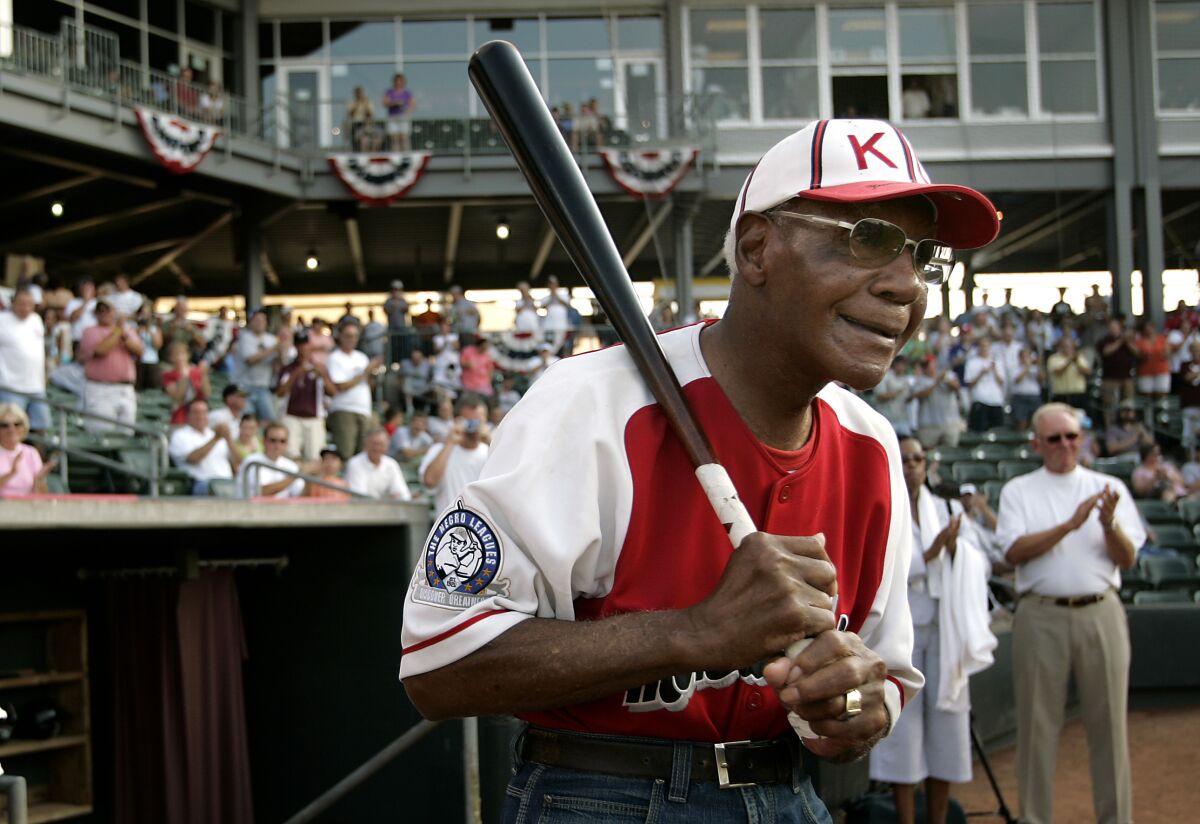 FILE - Buck O'Neil walks to the field as he is introduced before a minor league all-star game Tuesday, July 18, 2006, in Kansas City, Kan. O’Neil, a champion of Black ballplayers during a monumental, eight-decade career on and off the field, has joined Gil Hodges, Minnie Minoso and three others in being elected to the baseball Hall of Fame, on Sunday, Dec. 5, 2021. (AP Photo/Charlie Riede, File)