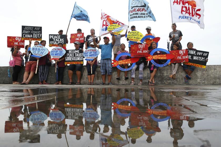 FILE - Protesters display placards and shout slogans in a continuing protest against China over its coast guards' alleged seizure of fish caught by Filipino fishermen near the contested Scarborough Shoal in the South China Sea on June 14, 2018 by the baywalk in Manila, Philippines. Philippine officials on Monday, Sept. 25, 2023 condemned a floating barrier laid by Chinese coast guard vessels to prevent Filipino fishermen from entering a disputed lagoon in the South China Sea and said they would take actions to remove the obstruction. (AP Photo/Bullit Marquez, File)