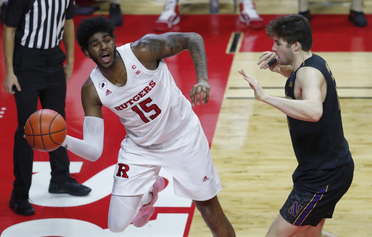 Rutgers center Myles Johnson keeps the ball in play against Northwestern center Ryan Young.