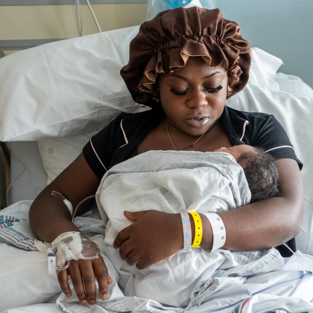 A woman with infant in a hospital bed.