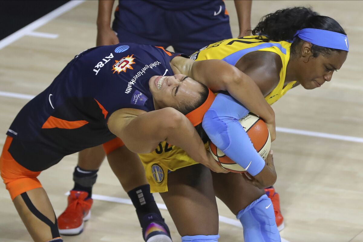 Connecticut Sun's Brionna Jones, left, reaches back to tie up a rebound with Chicago Sky's Cheyenne Parker during the second half of a WNBA basketball game Saturday, Aug. 8, 2020, in Bradenton, Fla. (AP Photo/Mike Carlson)