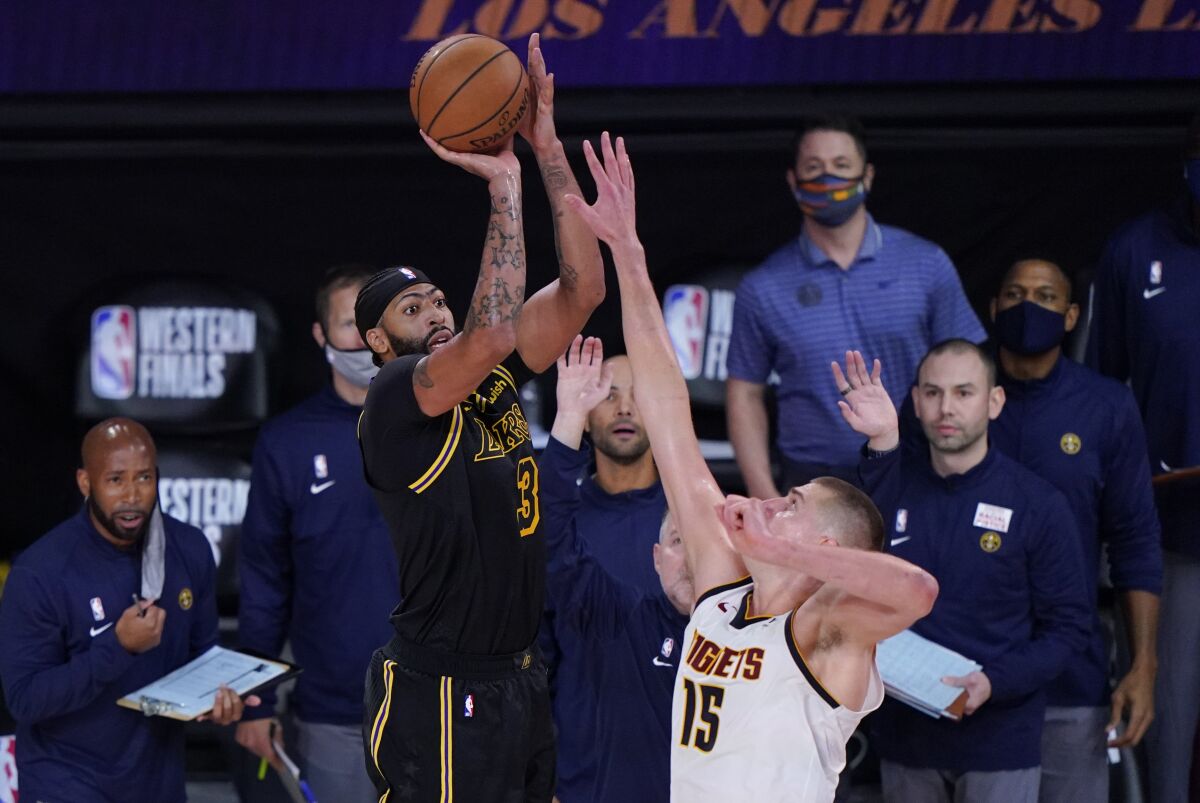 Lakers forward Anthony Davis has what proved to be his game-winning three-pointer challenged by Nuggets center Nikola Jokic.