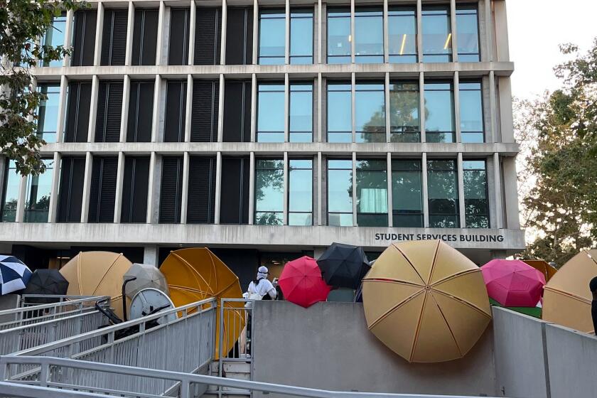 Protesters at CalState L.A. created a barrier including large umbrellas as they occupied the student services building on Wednesday, June 12, 2024 at the Los Angeles campus..
