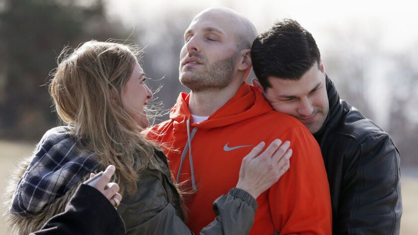 Michael Behenna is embraced by his brother Brett and his girlfriend, Shannon Wahl. President Trump pardoned Behenna, a former U.S. soldier convicted in 2009 of killing an Iraqi prisoner.
