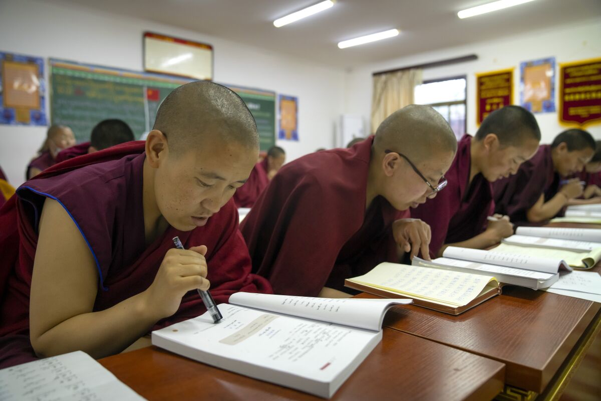 Tibetan Buddhist nuns read from their textbooks as they attend a Chinese language learning class at the Tibetan Buddhist College near Lhasa in western China's Tibet Autonomous Region, Monday, May 31, 2021. China is launching an aggressive campaign to promote Mandarin, saying 85% of its citizens will use the national language by 2025. The move appears to put threatened Chinese regional dialects such as Cantonese and Hokkien under even greater pressure, along with minority languages such as Tibetan, Mongolian and Uyghur. (AP Photo/Mark Schiefelbein)