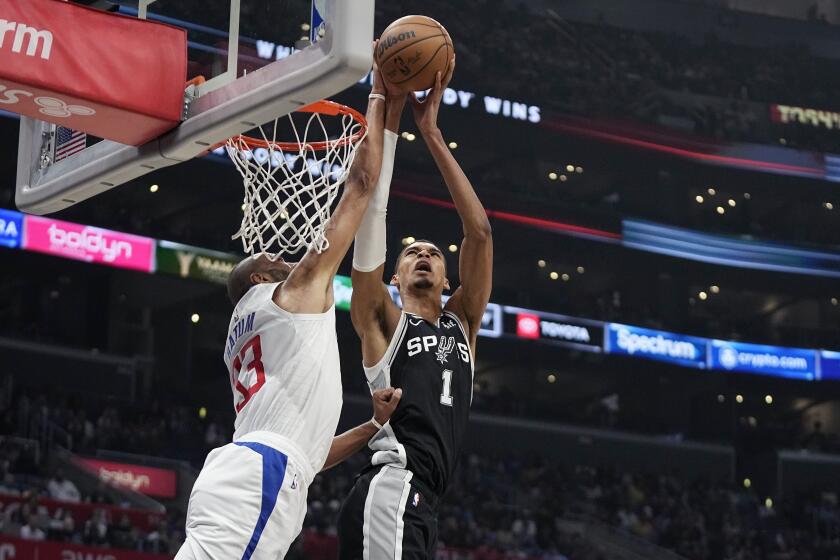 San Antonio Spurs center Victor Wembanyama, right, shoots as Los Angeles Clippers forward Nicolas Batum defends during the first half of an NBA basketball game Sunday, Oct. 29, 2023, in Los Angeles. (AP Photo/Mark J. Terrill)