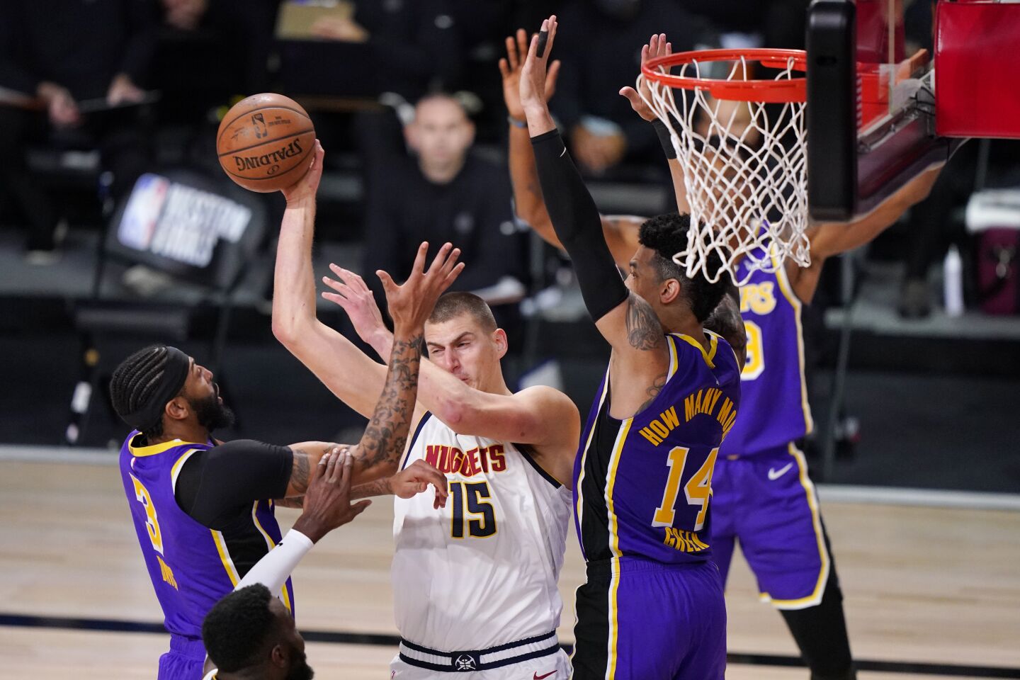 Nuggets center Nikola Jokic looks to pass after driving into the defense of Anthony Davis, left, and Danny Green.