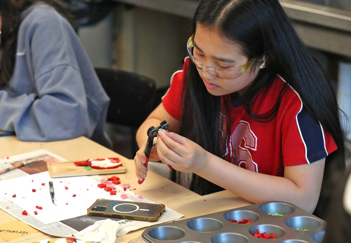 Student Veronica Cai works on a mosaic tile star as part of a workshop with Sawdust Festival artist Ron Shearer.