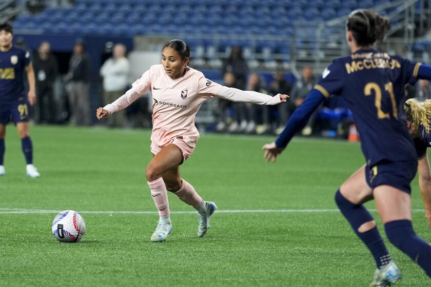 Angel City FC forward Alyssa Thompson moves the ball against Seattle Reign defender Phoebe McClernon.