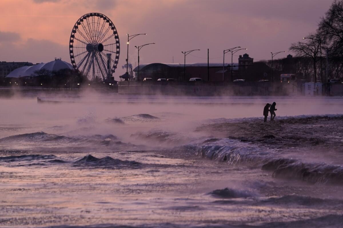 Varias personas caminan por una playa cubierta de hielo