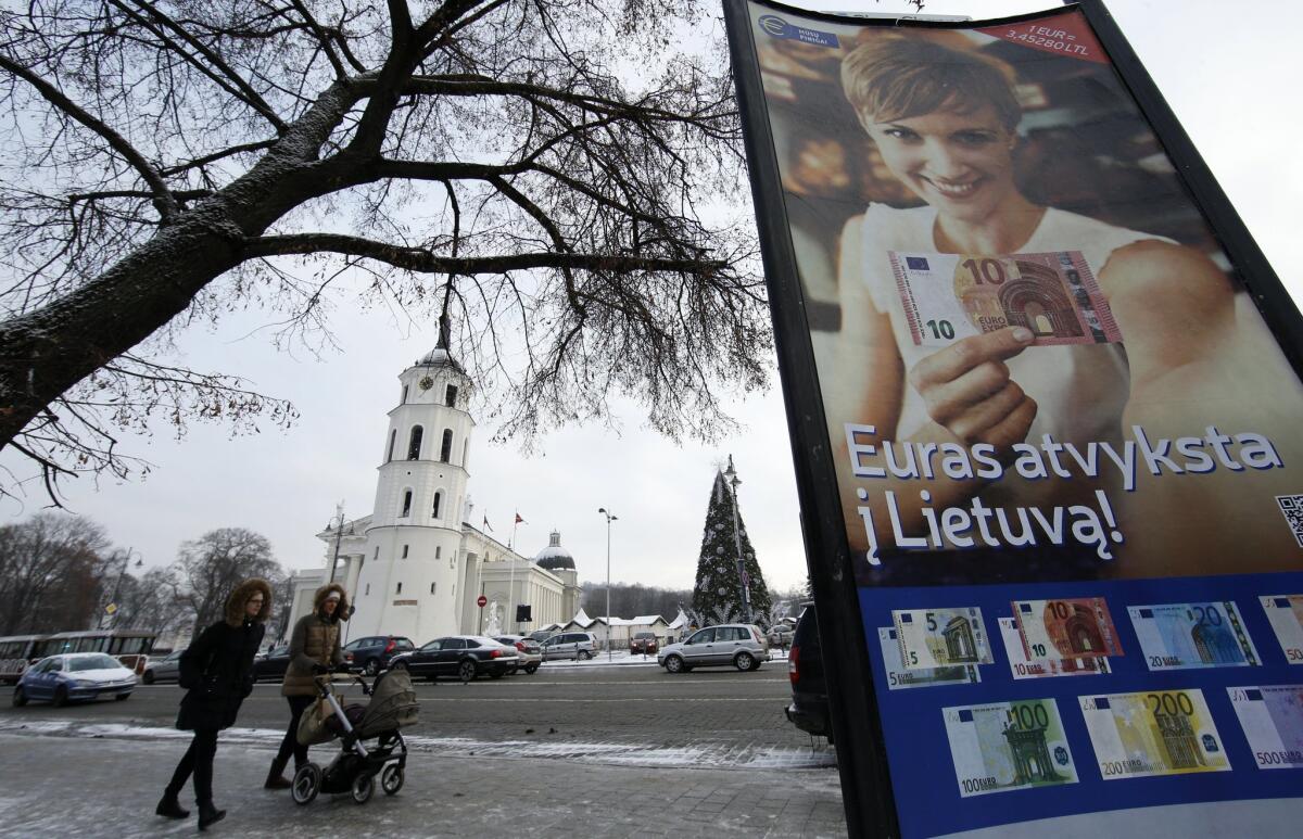 "The euro is coming to Lithuania," reads a poster in the capital of Vilnius on the eve of the former Soviet republic's adoption of the common currency on New Year's Day.