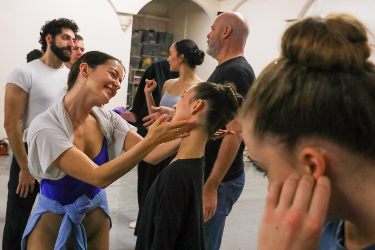 Dancers gathered in a rehearsal room, practicing and discussing a scene. 