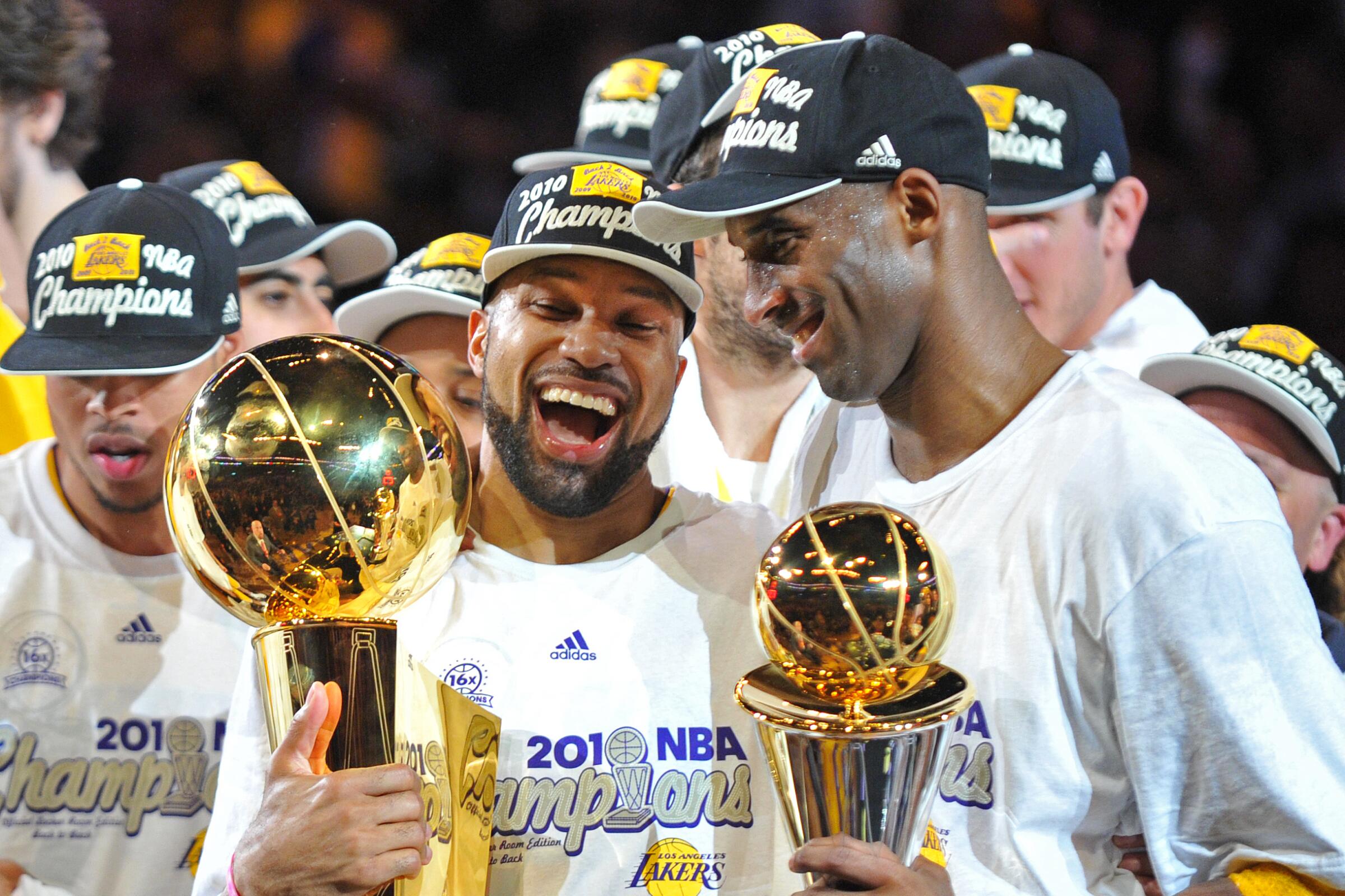 Lakers guards Derek Fisher and Finals MVP Kobe Bryant hold the trophies as they celebrate winning the 2010 NBA title.