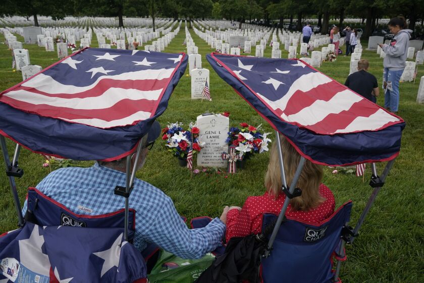 Eugene and Linda Lamie, of Homerville, Ga., sit by the grave of their son U.S. Army Sgt. Gene Lamie in Section 60 at Arlington National Cemetery on Memorial Day, Monday, May 29, 2023, in Arlington, Va. (AP Photo/Alex Brandon)