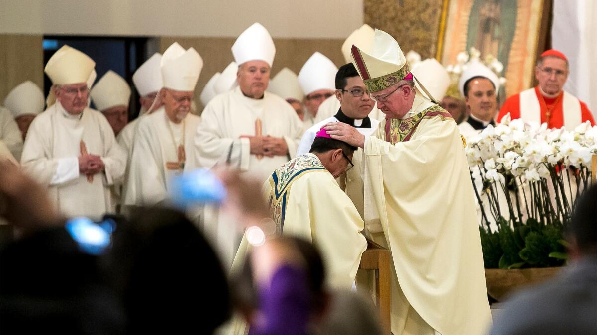 The Most Rev. Kevin Vann, bishop of Orange, lays his hands on the head of the Rev. Thomas Thanh Thai Nguyen during Nguyen's ordination as auxiliary bishop of Orange at St. Columban Church in Garden Grove on Dec. 19.