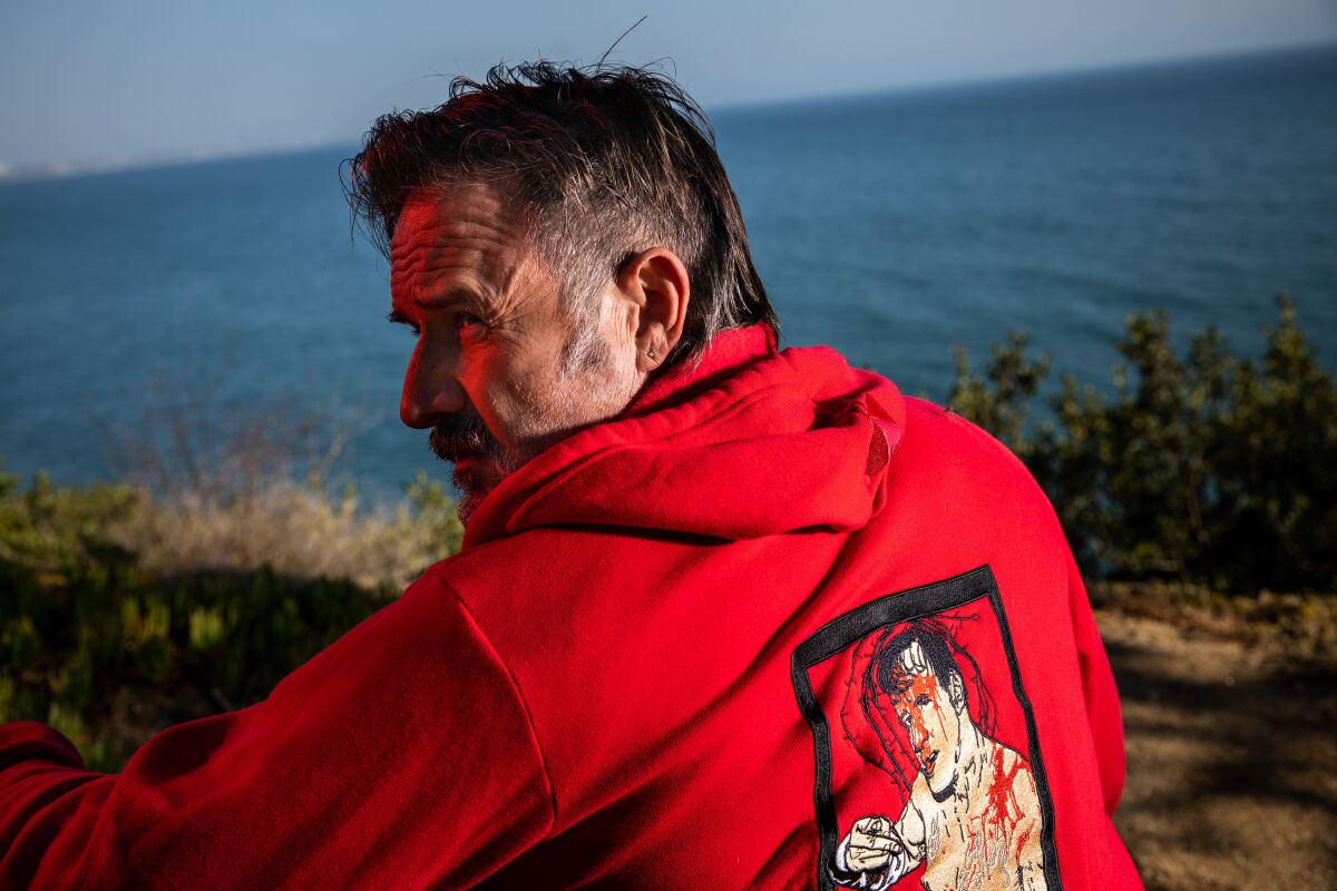 David Arquette wears a custom sweatshirt by Stitch Kings depicting an image of himself from his 2018 wrestling "deathmatch." 