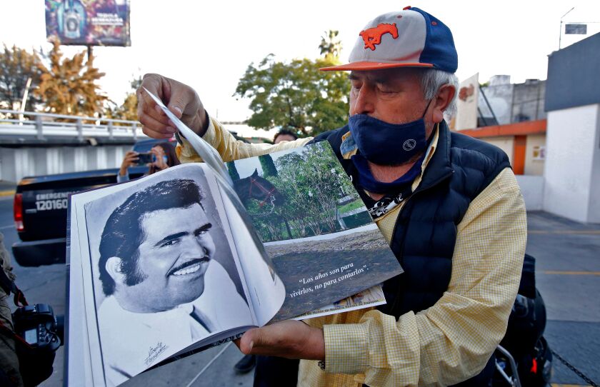 Miguel del Toro, 65, shows a book on Mexican singer Vicente Fernandez's life
