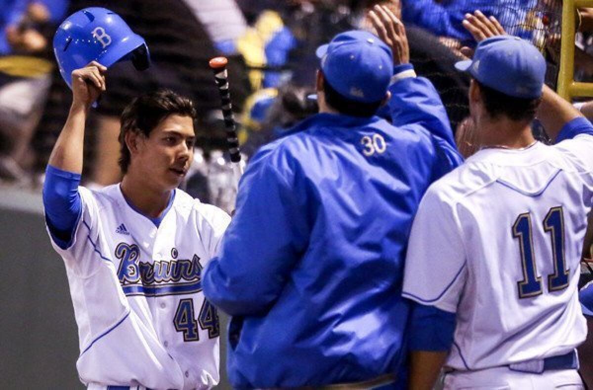 Brett Urabe (44) celebrates with UCLA teammates after scoring a run in the seventh inning against San Diego State on Friday night at Jackie Robinson Stadium.