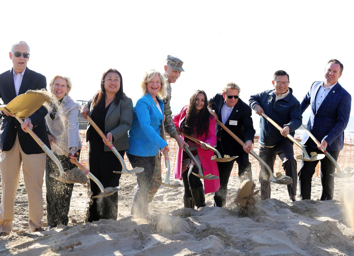 Local dignitaries shovel sand at the groundbreaking ceremony for the Surfside-Sunset Beach sand replenishment project.