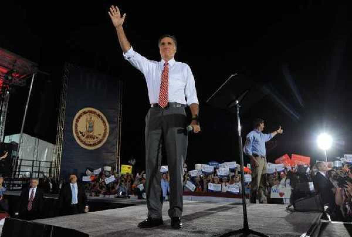 Mitt Romney and running mate Paul Ryan, in background, at a rally in Fishersville, Va.