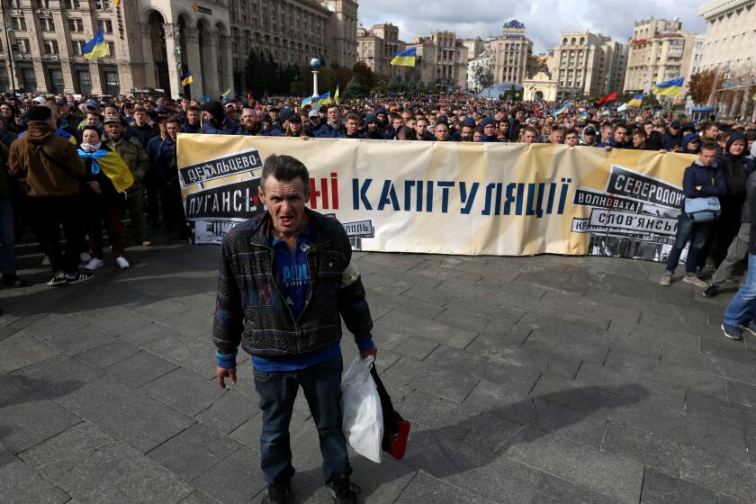 "No to Capitulation", reads a banner held by demonstrators in downtown Kyiv on Sunday.