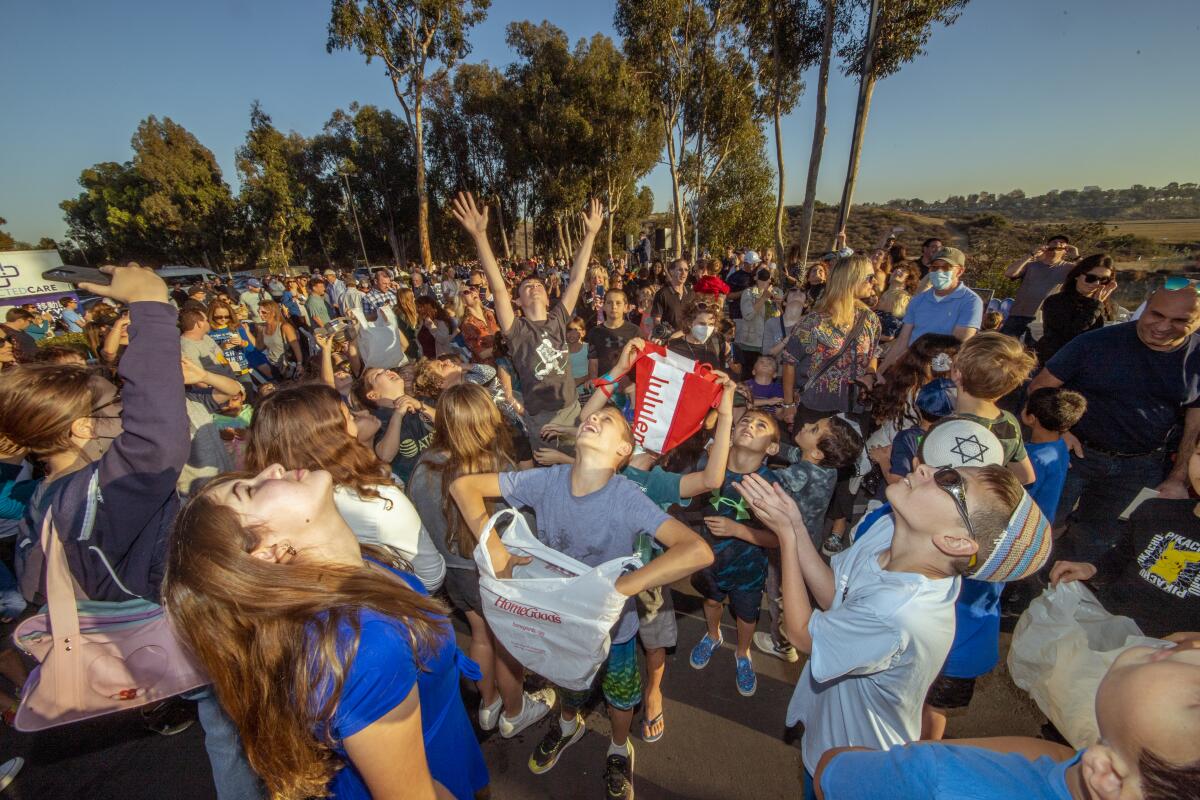 An eager crowd anticipates favors dropped from a Newport Beach Fire Department fire truck.