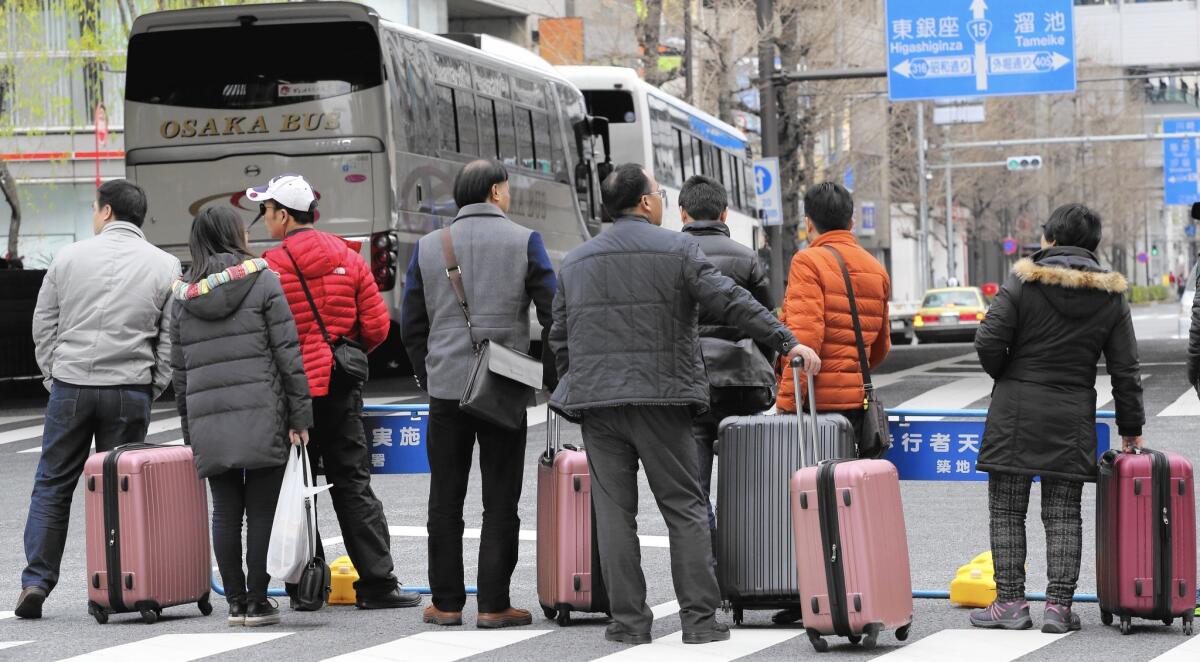 Chinese tourists wait for a bus in Tokyo's Ginza neighborhood.