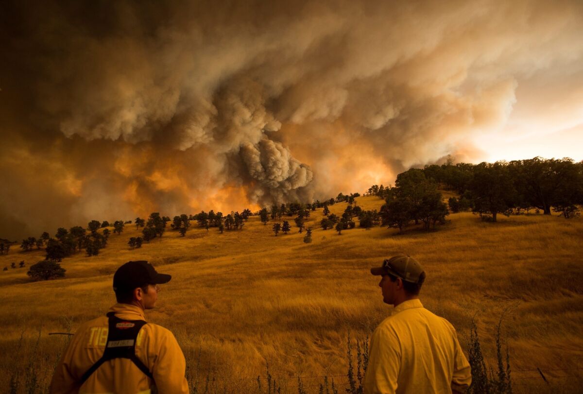 Firefighters watch as the Rocky fire burns near Clearlake, Calif., on Aug. 1.
