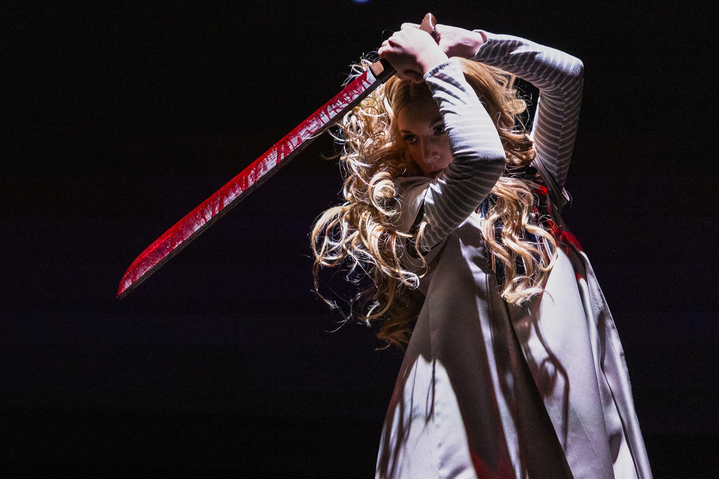 M3GAN dancer holds up a sword at Universal Studios Hollywood Horror Nights. 