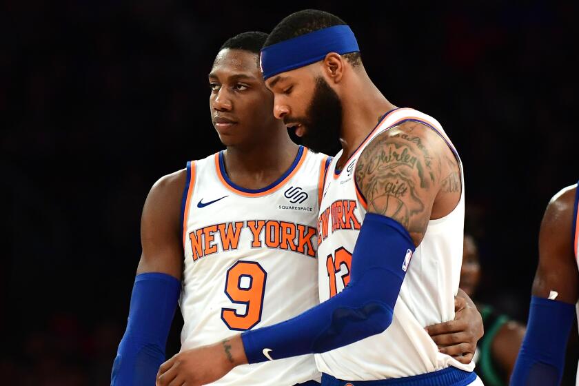 NEW YORK, NEW YORK - OCTOBER 26: Bobby Portis #1 looks on as RJ Barrett #9 hugs Marcus Morris Sr. #13 of the New York Knicks during the first half of their game against the Boston Celtics at Madison Square Garden on October 26, 2019 in New York City. NOTE TO USER: User expressly acknowledges and agrees that, by downloading and or using this photograph, User is consenting to the terms and conditions of the Getty Images License Agreement. (Photo by Emilee Chinn/Getty Images)